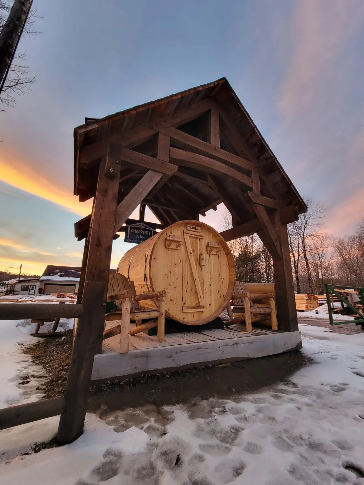 Handcrafted timber pavilion sheltering a barrel sauna at sunset