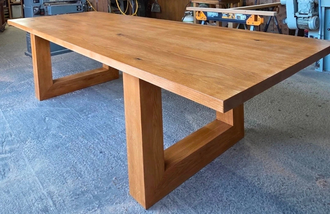 Oak dining table with a Portique base in the Aries Den workshop
